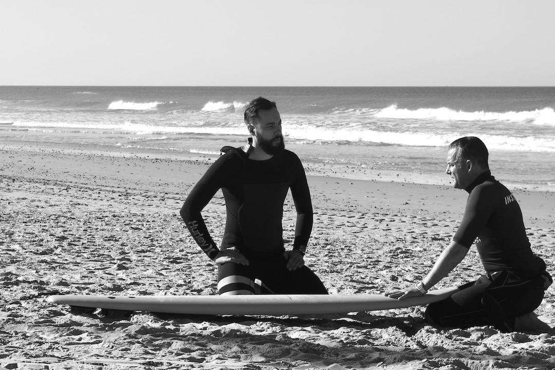Surfing instructor and student on the beach in Conil, Spain
