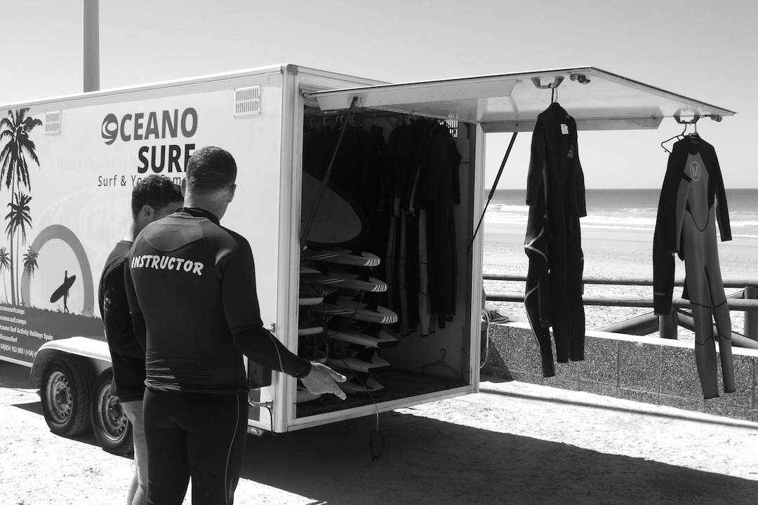 Surfing instructor in front of the Oceano Surf School car