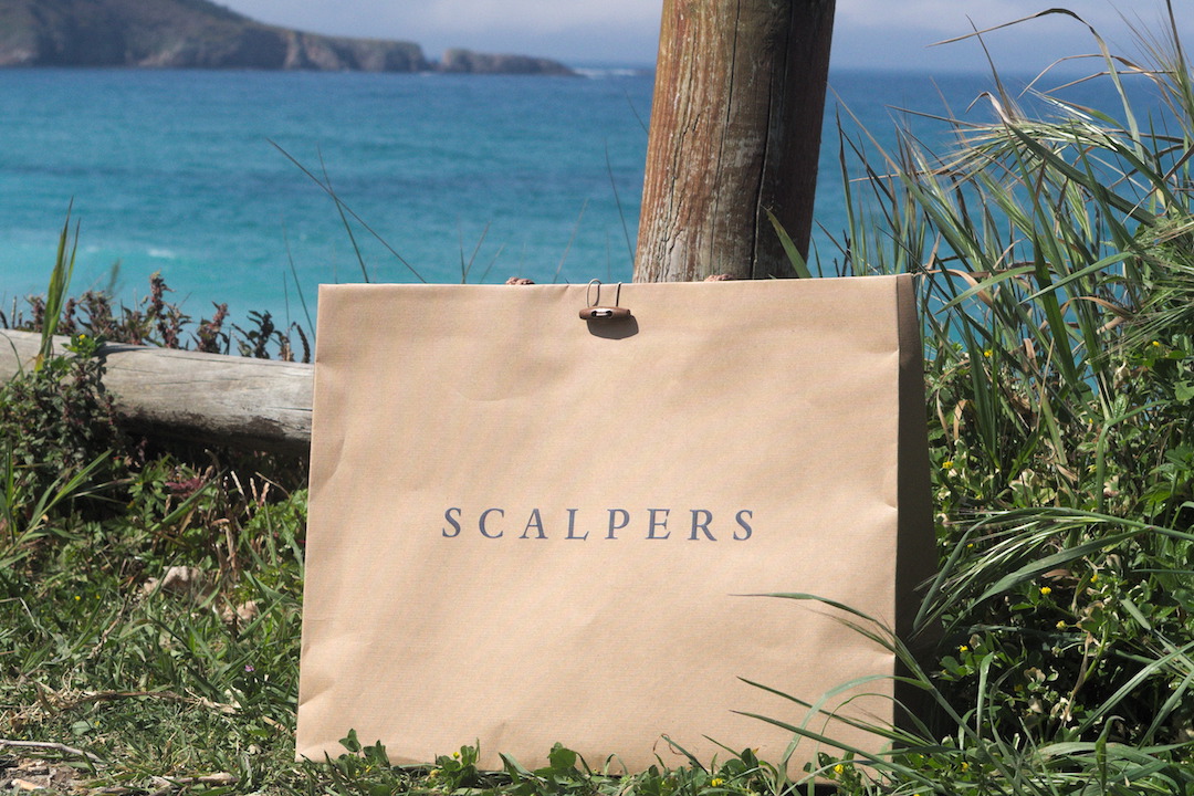 A picture of a Scalpers shopping bag on a beach