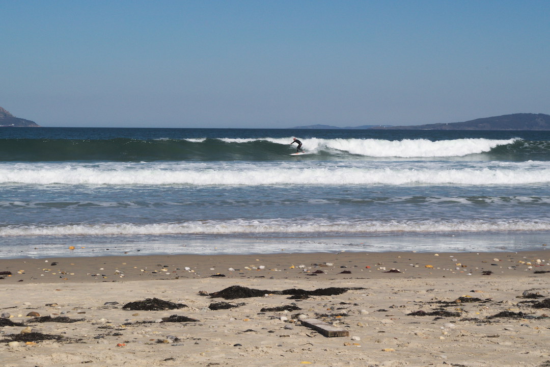 Picture of a surfer riding a wave on Patos beach in Galicia
