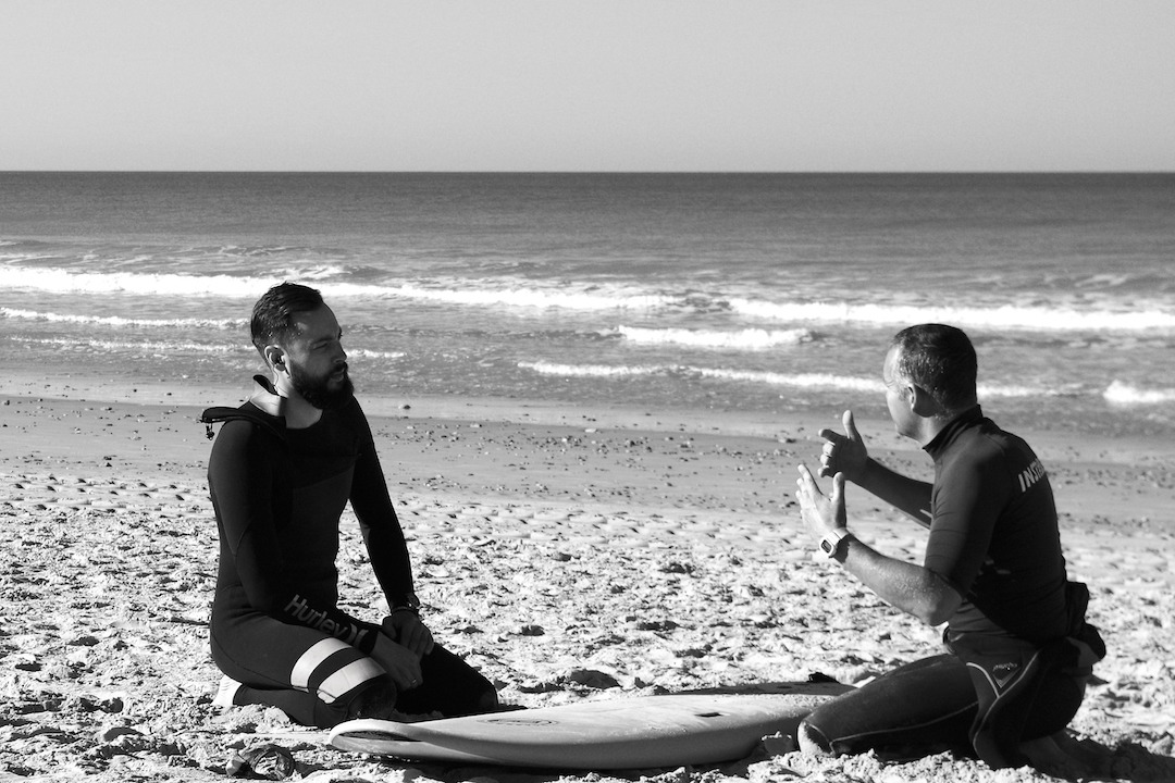 Surfing instructor and student on the beach in Conil, Spain
