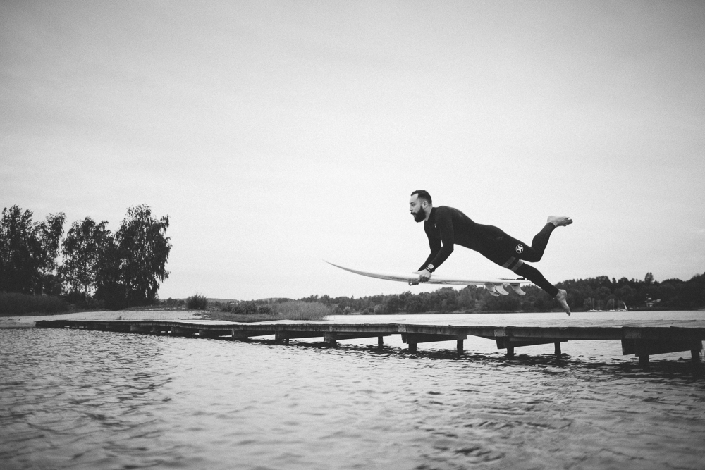 Picture of a surfer jumping of a lake bridge