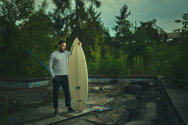 Picture of Son of a Beach blogger standing in abandoned swimming pool with a surfboard watching the sunset